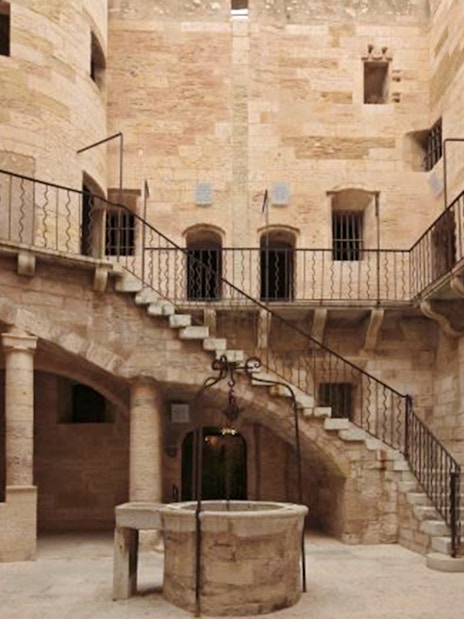 Château d’If courtyard with stone staircase and central well in Marseille, France.