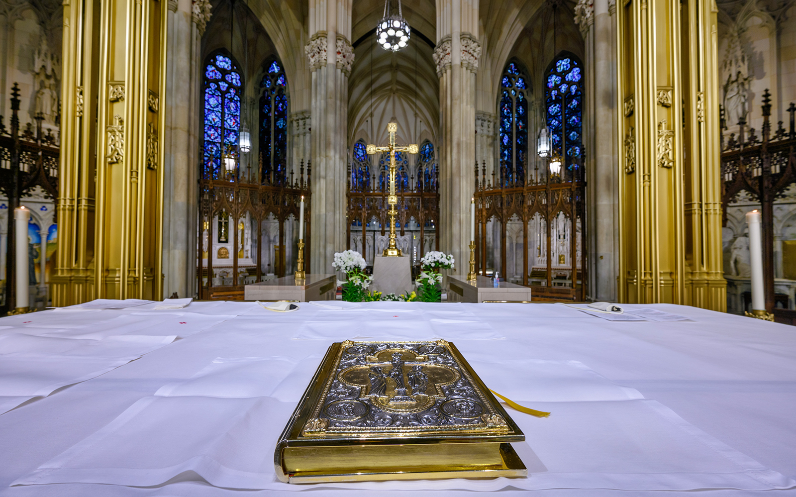 Altar view inside St. Patrick's Cathedral with ornate Bible and stained glass windows.
