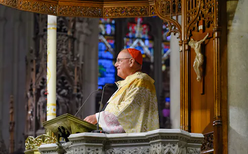 Clergy member speaking at St. Patrick's Cathedral pulpit, New York City.