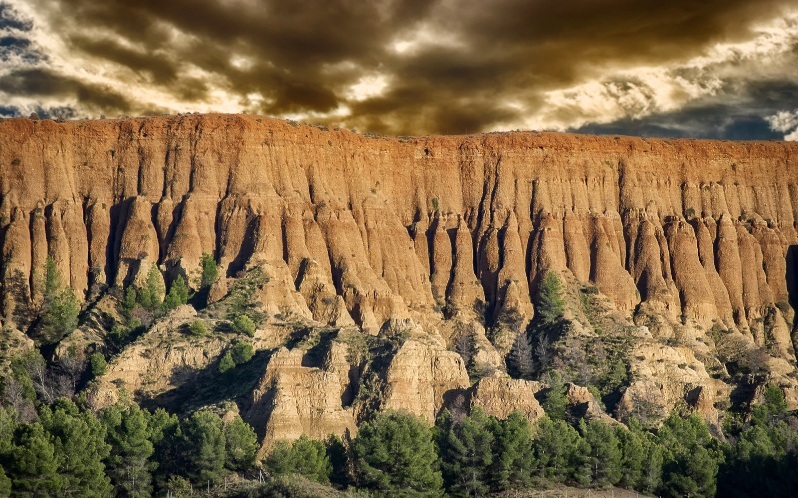 Granada Geopark desert landscape with unique rock formations and greenery.