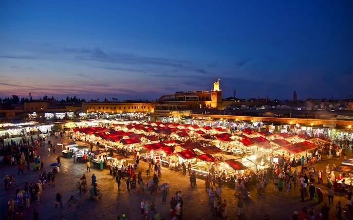 Jemaa el-Fnaa square bustling with food stalls and visitors at dusk in Marrakesh.