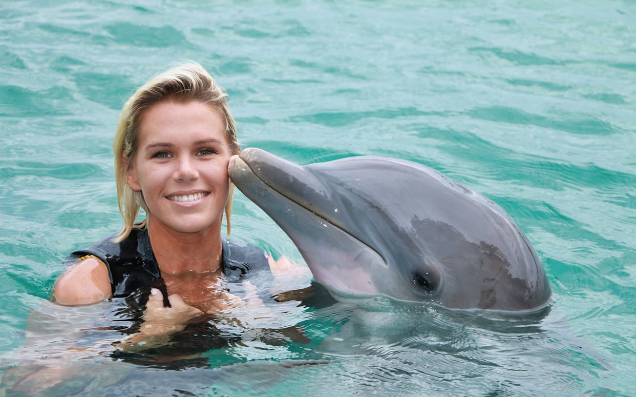 Person swimming with a dolphin at Chankanaab Park, Cozumel.