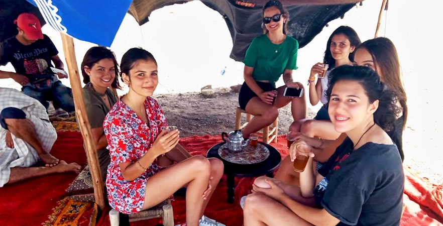 Group enjoying tea under a tent in Agafay Desert during Marrakesh camel and quad bike tour.