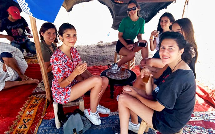 Group enjoying tea under a tent in Agafay Desert during Marrakesh camel and quad bike tour.