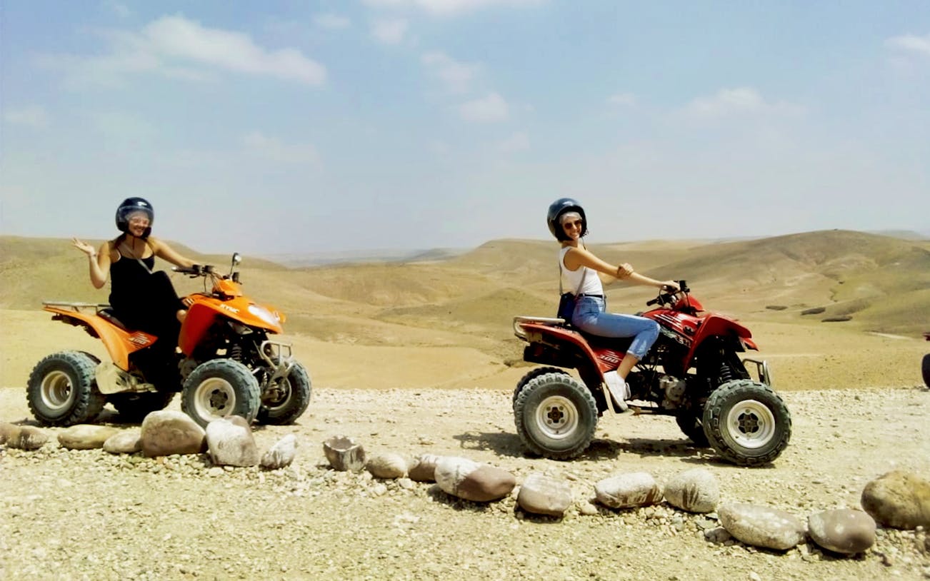 Two people riding quad bikes in the Agafay Desert near Marrakesh.