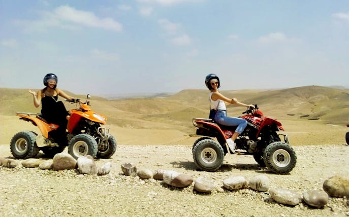 Two people riding quad bikes in the Agafay Desert near Marrakesh.