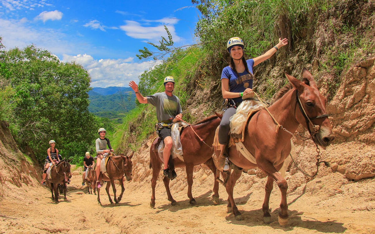 Horseback riders on a trail in Banderas Bay jungle, part of an outdoor adventure tour.