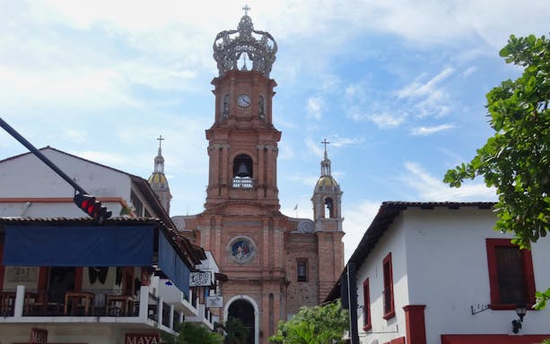 Church of Our Lady of Guadalupe in Puerto Vallarta with surrounding street view.
