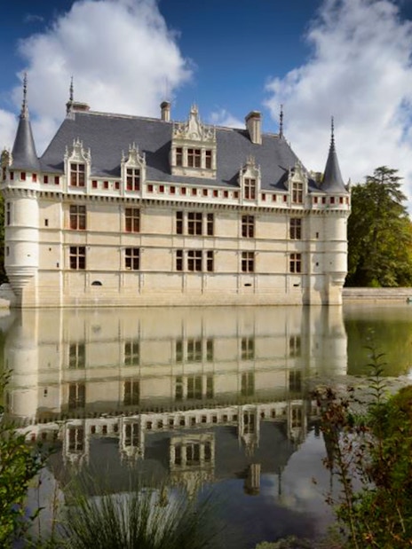 Château of Azay-le-Rideau reflecting in a tranquil moat, surrounded by lush greenery.