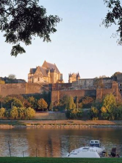Panoramic view of Angers Castle with river and boats in foreground, France.