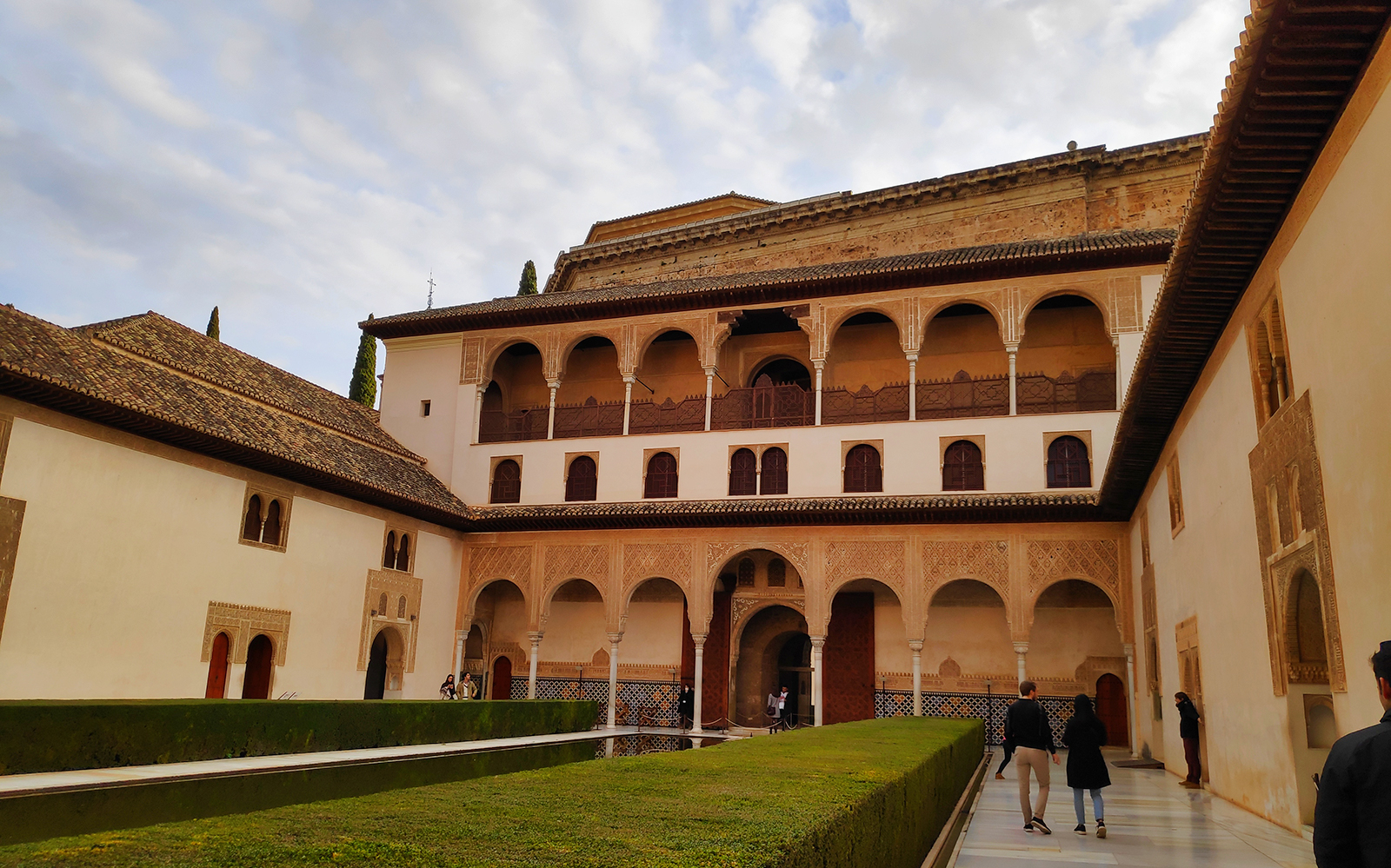 Alhambra courtyard with arches and intricate carvings, Granada tour.