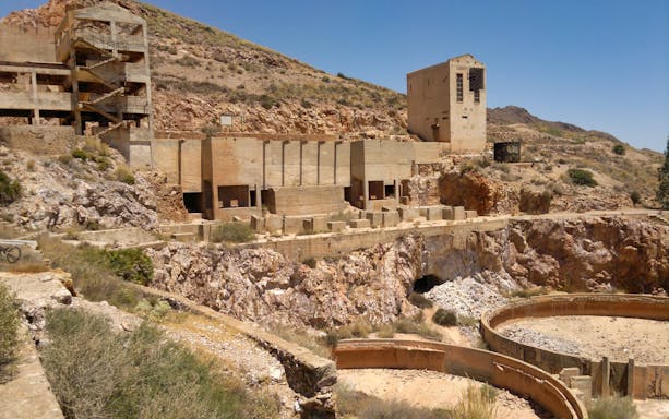 Abandoned mining structures in Cabo de Gata, Almería, surrounded by rocky terrain.
