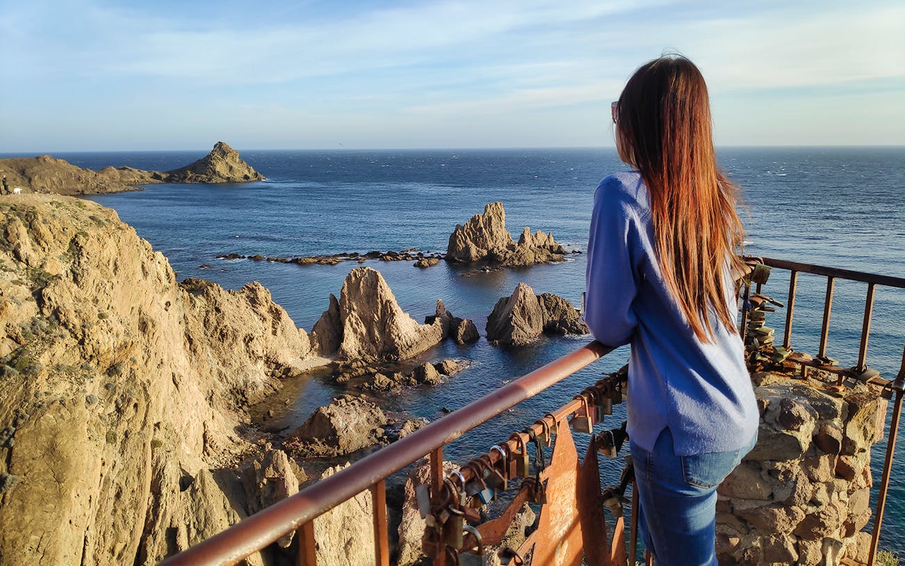 Woman overlooking rocky coastline at Cabo de Gata during full day trip from Almería.