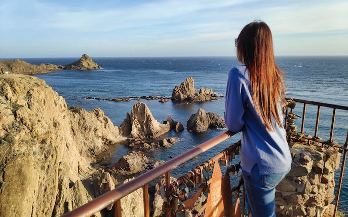 Woman overlooking rocky coastline at Cabo de Gata during full day trip from Almería.