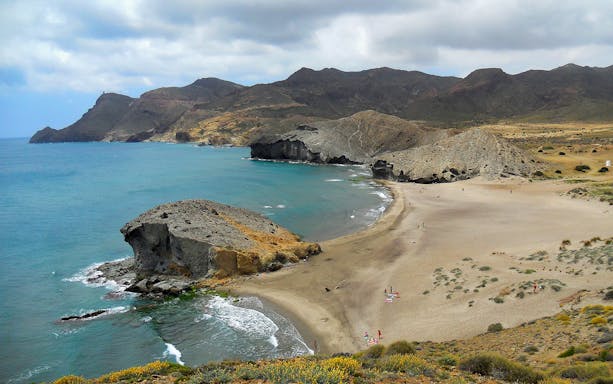 Cabo de Gata coastline with sandy beach and rocky cliffs on a day trip from Almería.