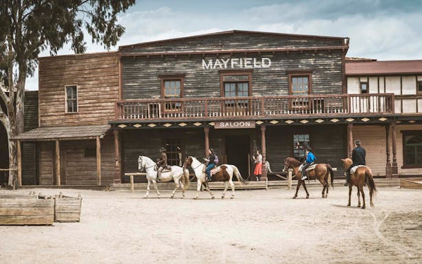 Riders on horseback in front of Mayfield Saloon at Fort Bravo, Tabernas Desert.