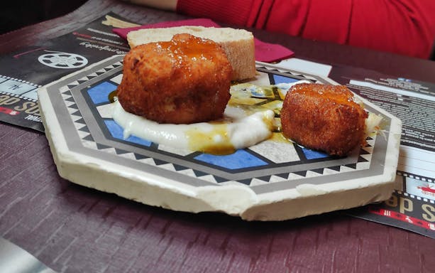 Croquettes on a decorative plate with bread, featured in Almeria's city center tapa tour.