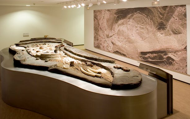 Archaeological exhibit in Almeria museum showcasing ancient artifacts and site map.