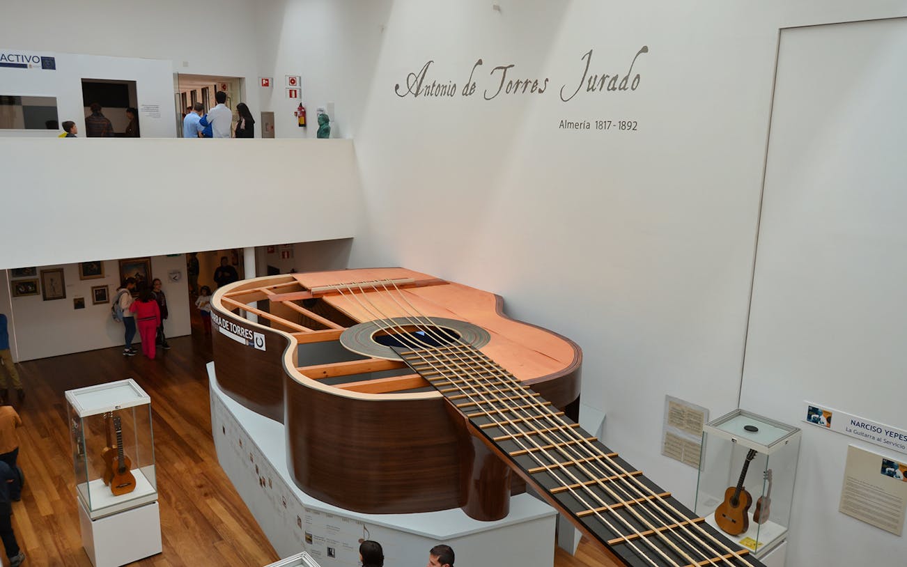 Giant guitar exhibit at the Antonio de Torres Museum in Almeria, showcasing local musical heritage.