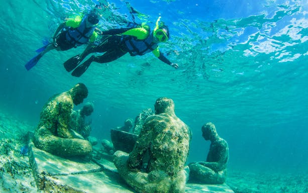 Snorkelers exploring underwater sculptures at Cancun's MUSA with Go Cancun Pass.