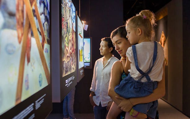 Family exploring art exhibit in Cancun museum with Go Cancun Pass.