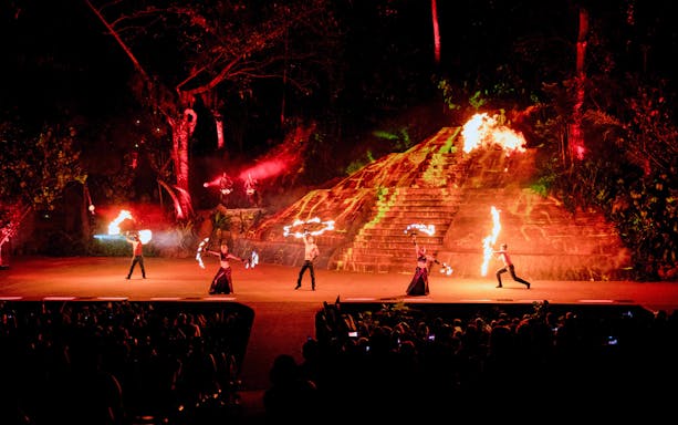 Fire performers at Rhythms of the Night Dinner Show in front of illuminated pyramid.