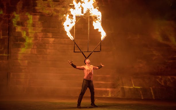 Performer balancing flaming structure at Rhythms of the Night: VIP Dinner Show.
