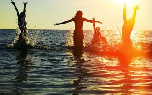 People enjoying the sunset in the ocean at Sayulita Beach, Mexico.
