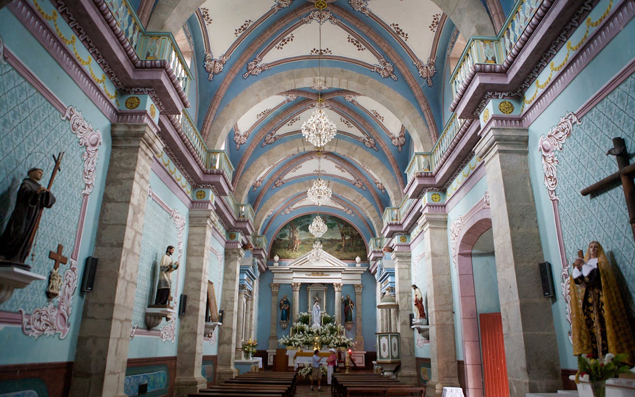 Interior of a historic church in San Sebastian with ornate arches and religious statues.