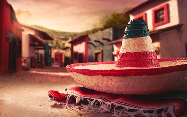 Sombrero on a colorful blanket in a rustic street of San Sebastian, Mexico.