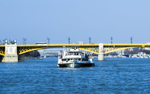 Cruise boat on the River Danube approaching Margaret Bridge in Budapest.