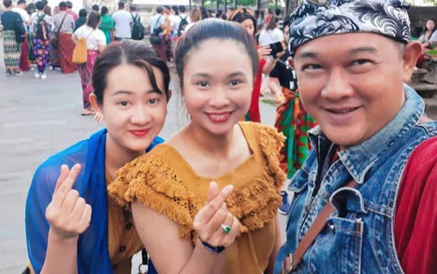 Tourists enjoying Bali's Gate of Heaven during a sunrise or sunset tour.