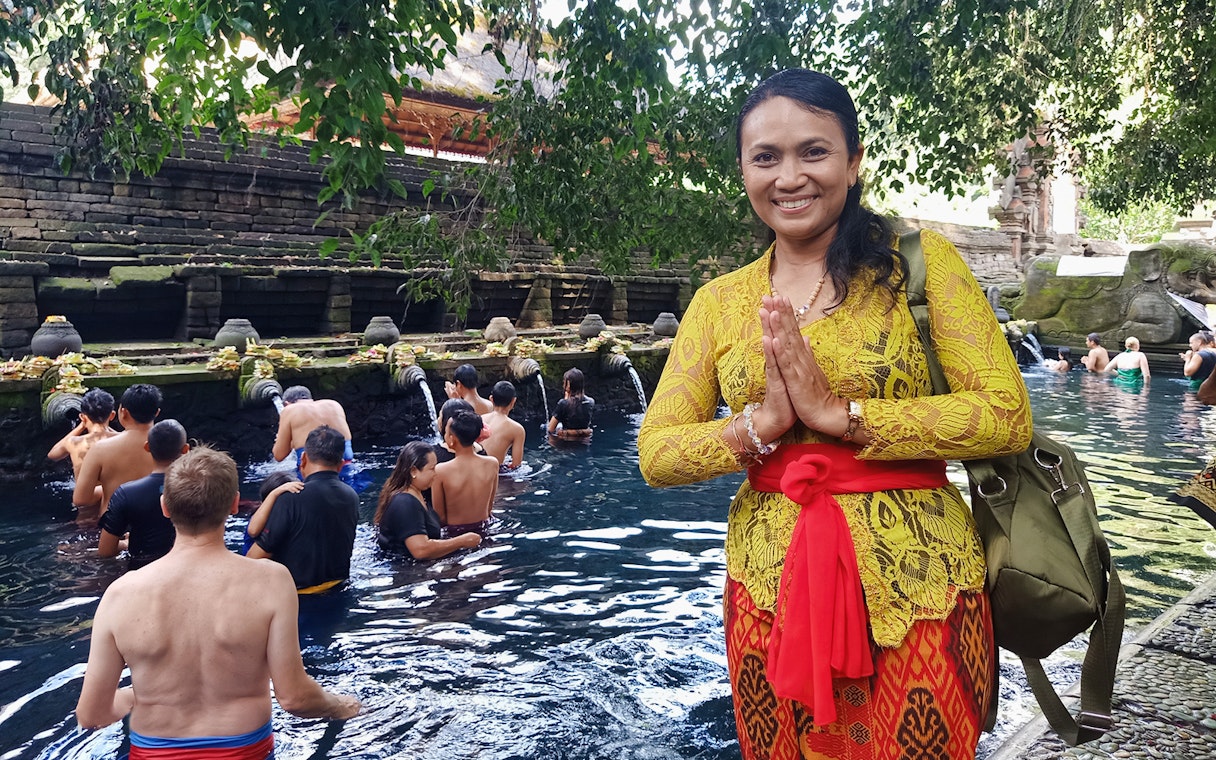 Visitors at Tirta Empul temple in Bali participating in a traditional water purification ritual.