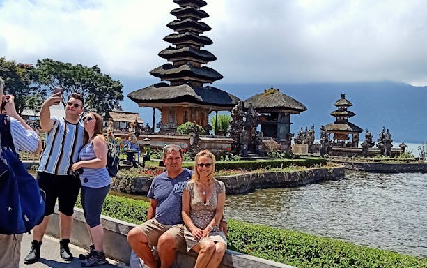 Bali Bedugul temple with tourists taking photos by the water.