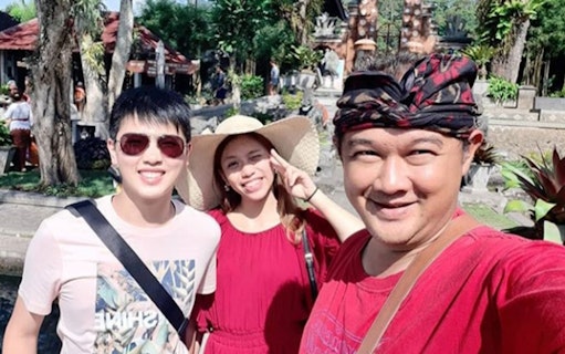 Group of tourists at Ulundanu Beratan Temple, Bali, enjoying a sunny day.