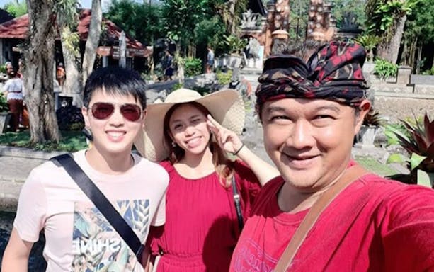 Group of tourists at Ulundanu Beratan Temple, Bali, enjoying a sunny day.