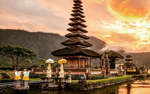 Ulundanu Beratan Temple at sunrise in Bali with mountains in the background.