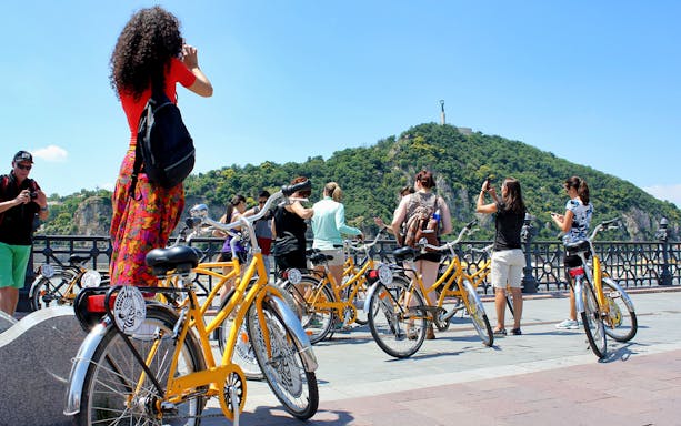 Cyclists enjoying Budapest Danube River views during a bike ride.