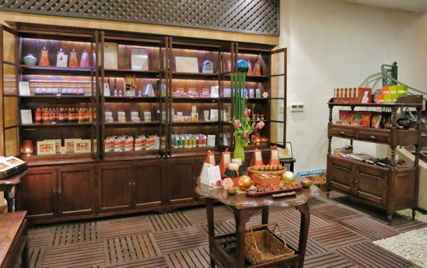 Spa products displayed on wooden shelves at Let's Relax Four Hands Thai Massage.