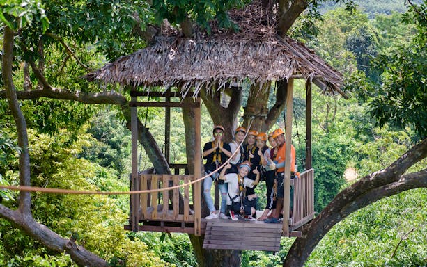 Group preparing for zipline adventure in Phuket treetop platform.