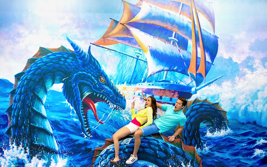 Couple posing with sea dragon mural at Aquaria Phuket.