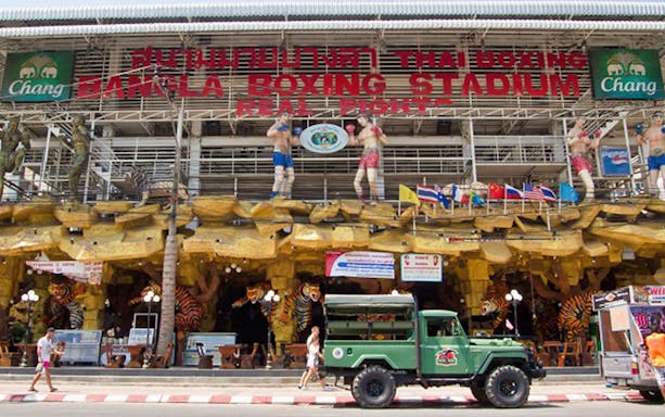 Bangla Boxing Stadium entrance with statues and flags in Patong, Thailand.