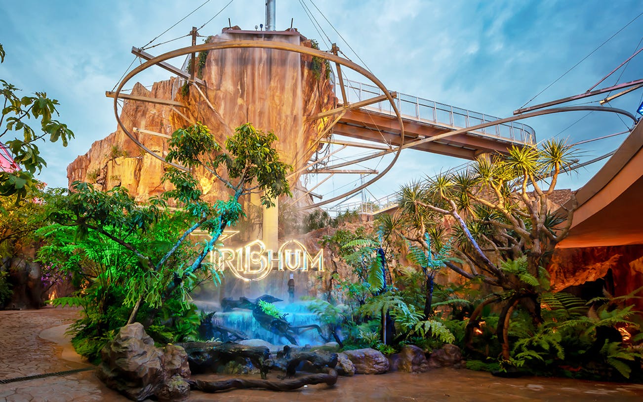 Tribhum Adventure Park entrance with waterfall and lush greenery.