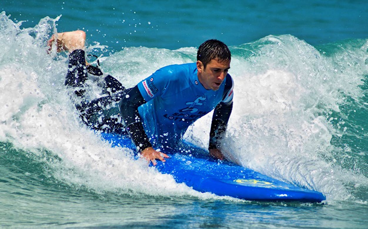 Surfer learning on a blue board in Lembongan, Bali.