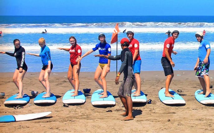 Surf instructor guiding group lesson on Lembongan beach, Bali.