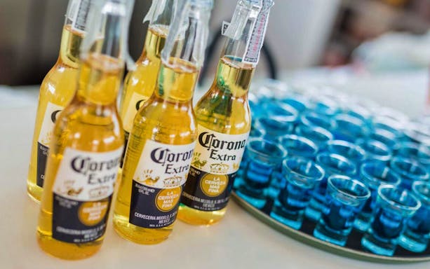 Bottles of beer and blue shot glasses on a table during Phi Phi Island tour.