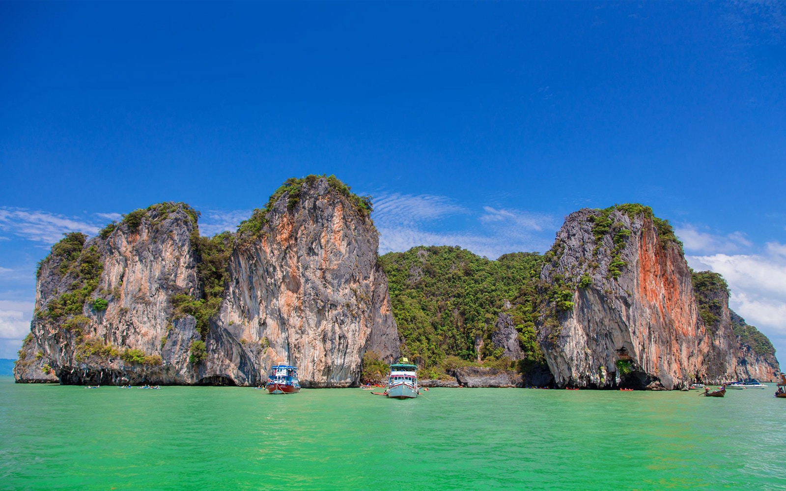 Speed boats near limestone cliffs at James Bond Island, Phang Nga, Thailand.