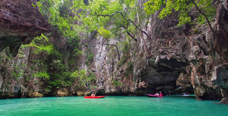 Kayakers exploring limestone cliffs and emerald waters on James Bond Island, Phang Nga.