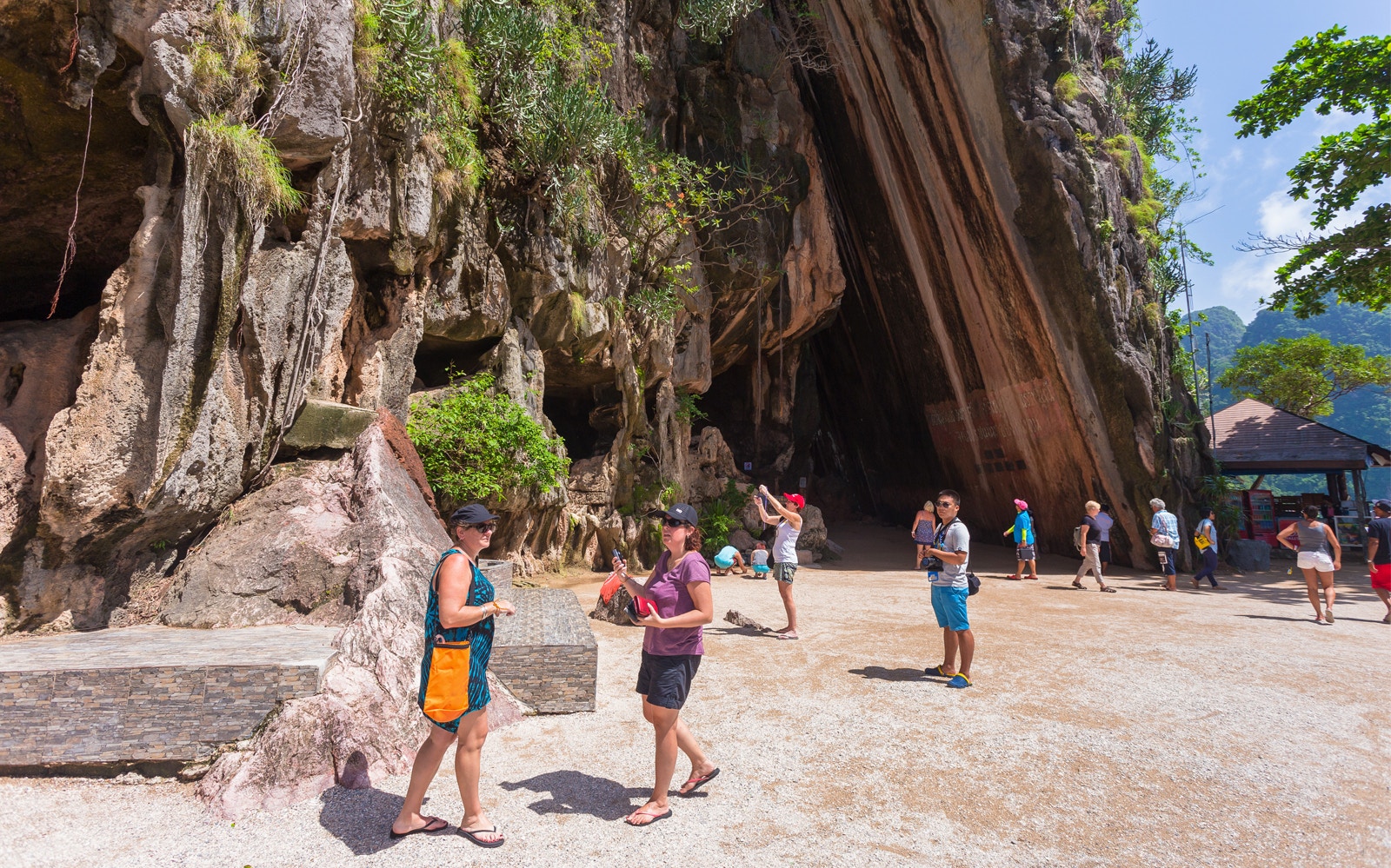 Tourists exploring limestone cliffs at James Bond Island, Phang Nga, during a day trip.