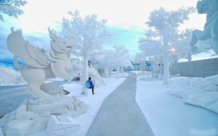 Pathway through ice sculptures at Frost Magical Ice of Siam, featuring mythical creatures.